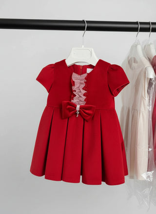 Red dress with a bow on a rack in a store setting